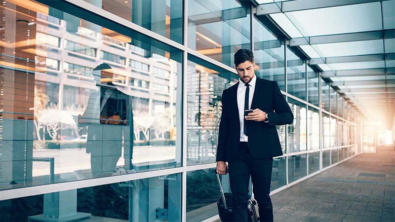 A man with a suitcase and a smartphone