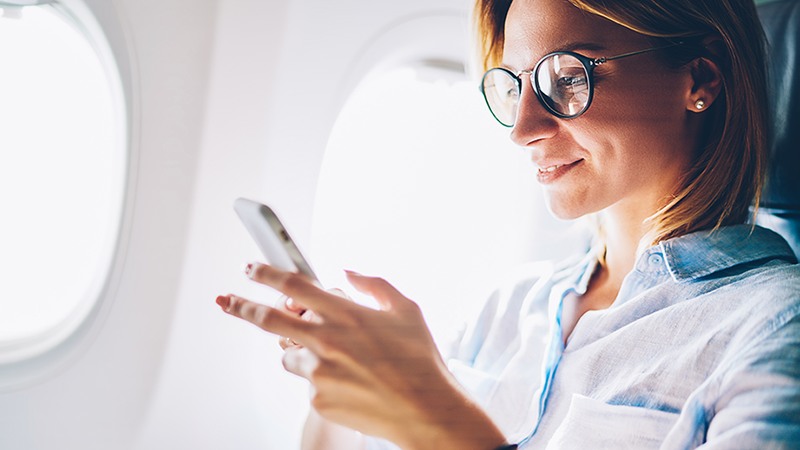 A woman with a smartphone in the airplane